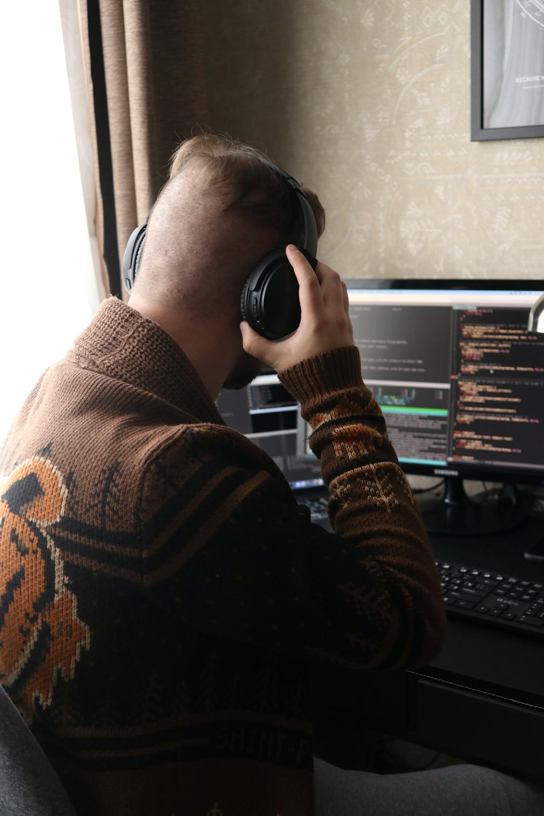 creative-03 a-man-sitting-in-front-of-a-computer-with-headphones-on-uk5khhsdpk0